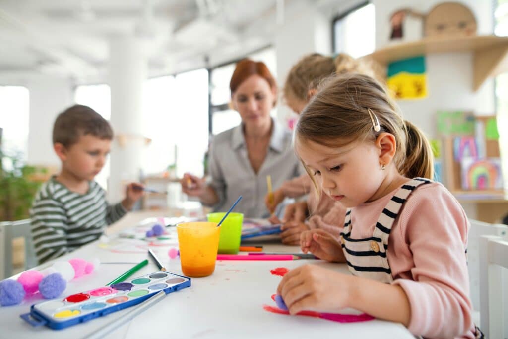 Children painting and drawing with an educator