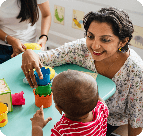 Educator with baby, block play.
