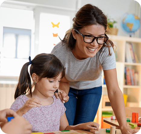 Educator assisting a child with blocks.