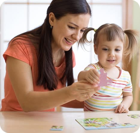 Educator helping child with a puzzle.